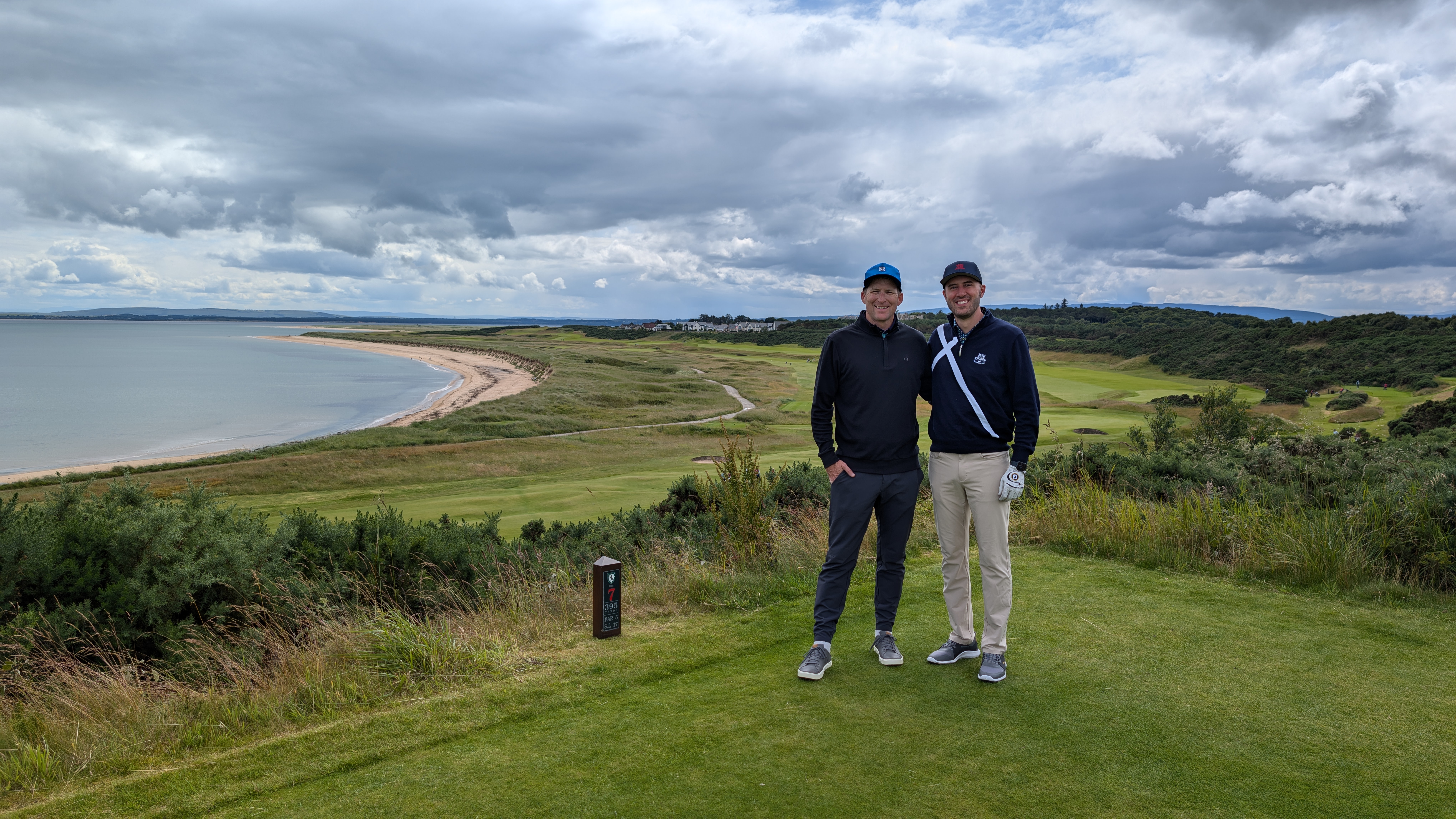 Two golfers on a links course with the ocean behind them